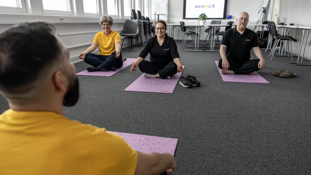 Fyra Samhallsanställda tränar yoga tillsammans. 