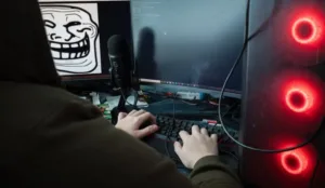 Datorhackare som sitter framföre en bildskärm med fingrarna på ett tangentbord.