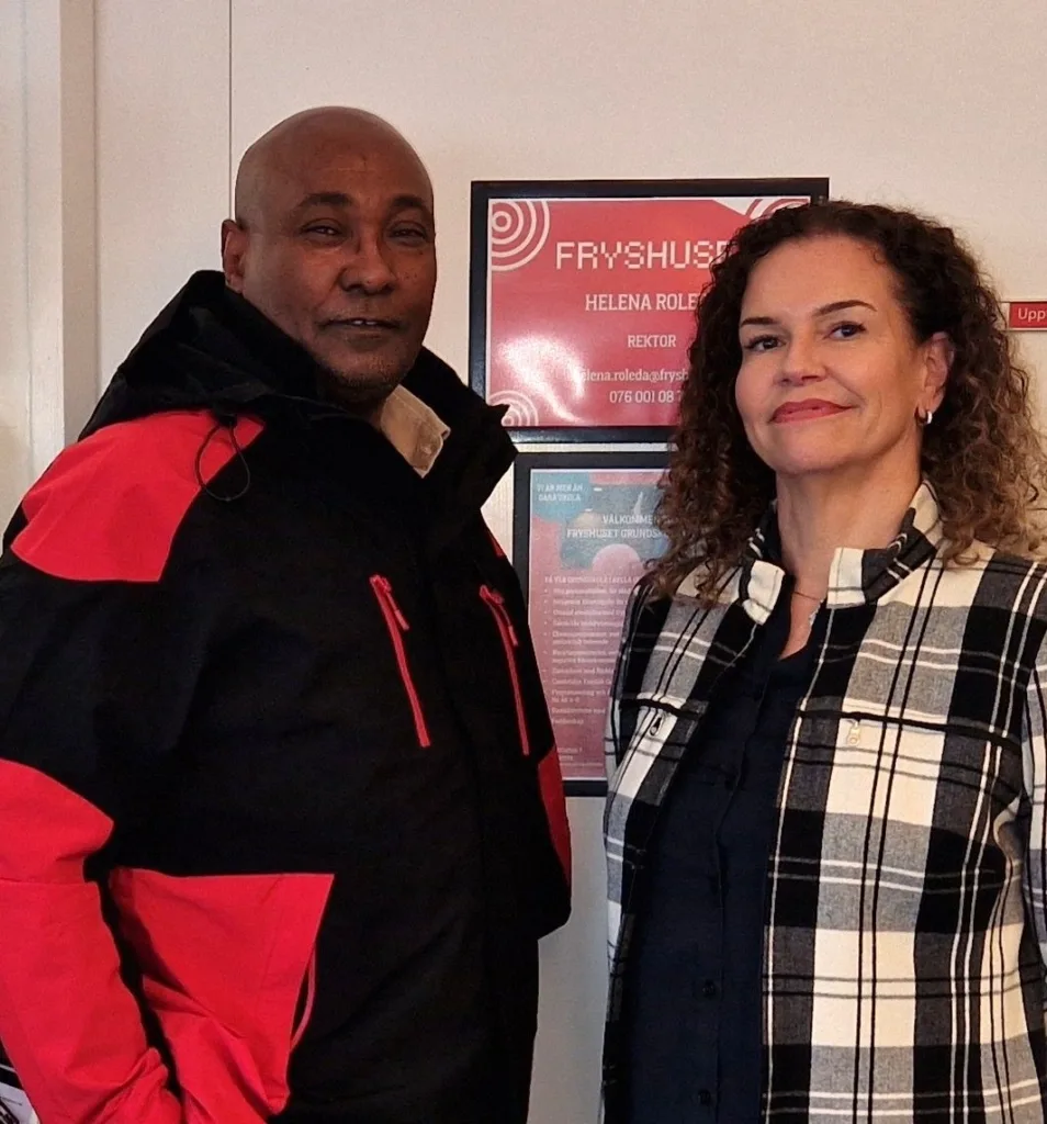 Yakem som fått jobb på Fryshuset. Han står bredvid skolans rektor.